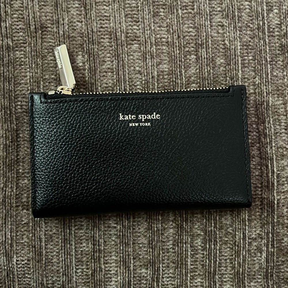 Kate spade bi-fold Spencer Slim in black with gold tone hardware.